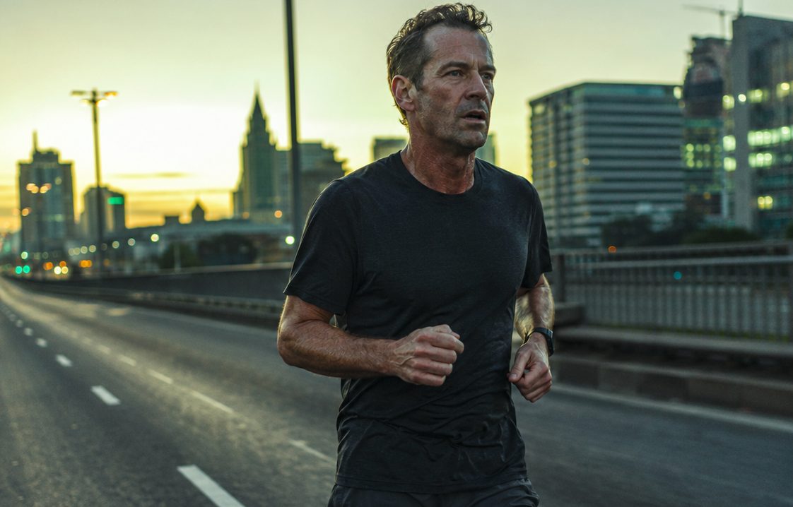 A runner alone on an empty city road at dawn